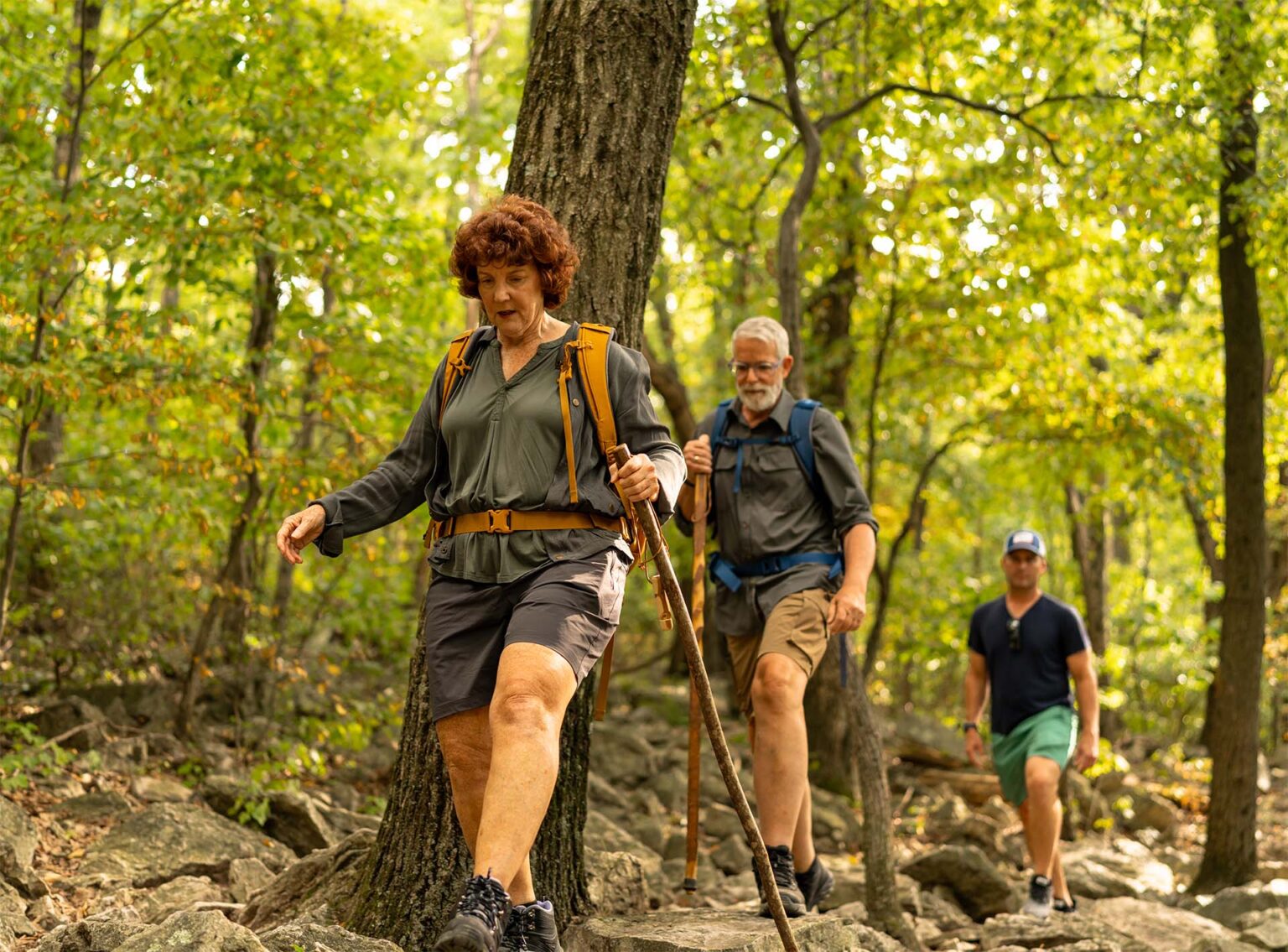 Wendy hiking through the woods with John and her son.