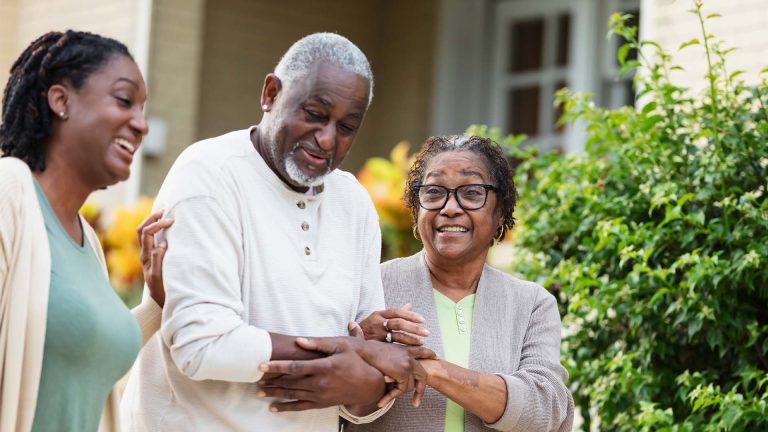 Senior African-American couple walking with daughter.