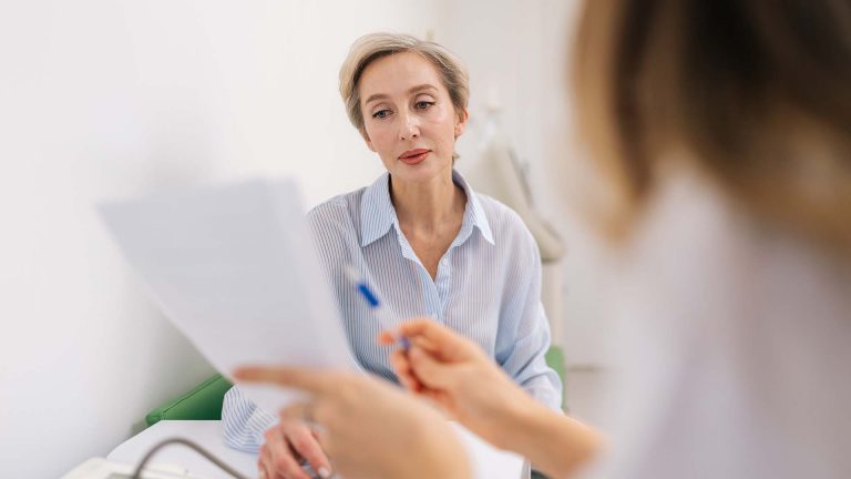 A woman discussing her health with a doctor in a medical office.