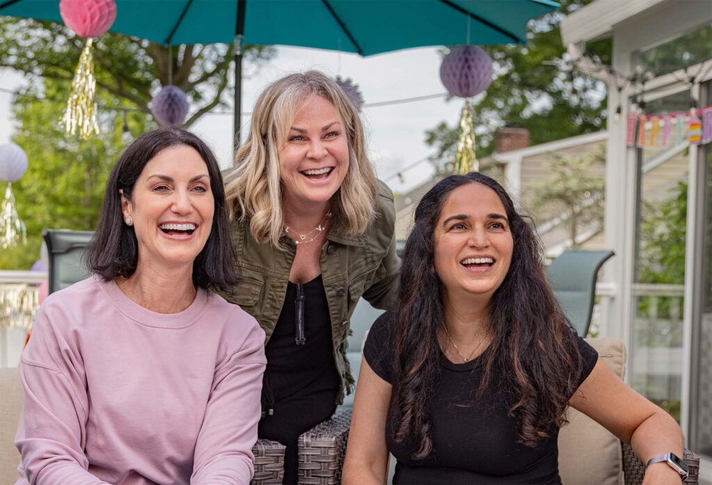 Alexis laughing with friends outdoors.