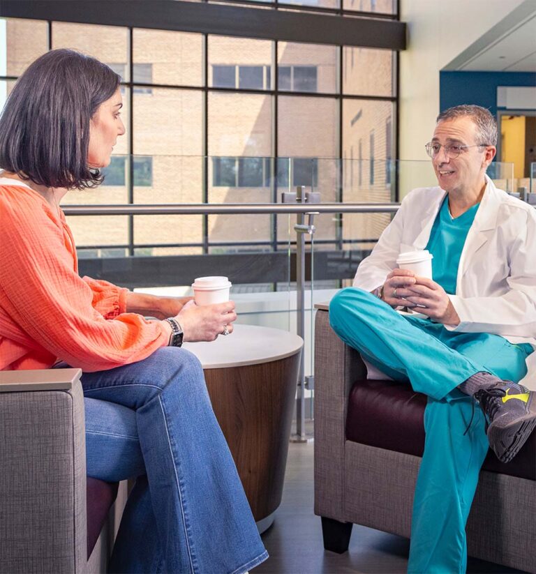 Dr. Topalian and Alexis chatting with coffee cups.