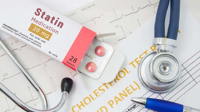 Statin medication, stethoscope, and test results.
