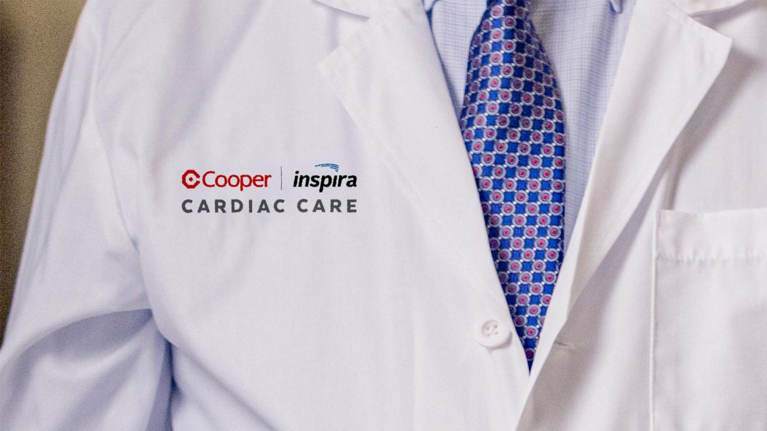 Physician's lab coat with Cooper and Inspira Cardiac Care on chest.