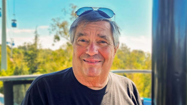 Vince smiling outdoors with sunglasses.
