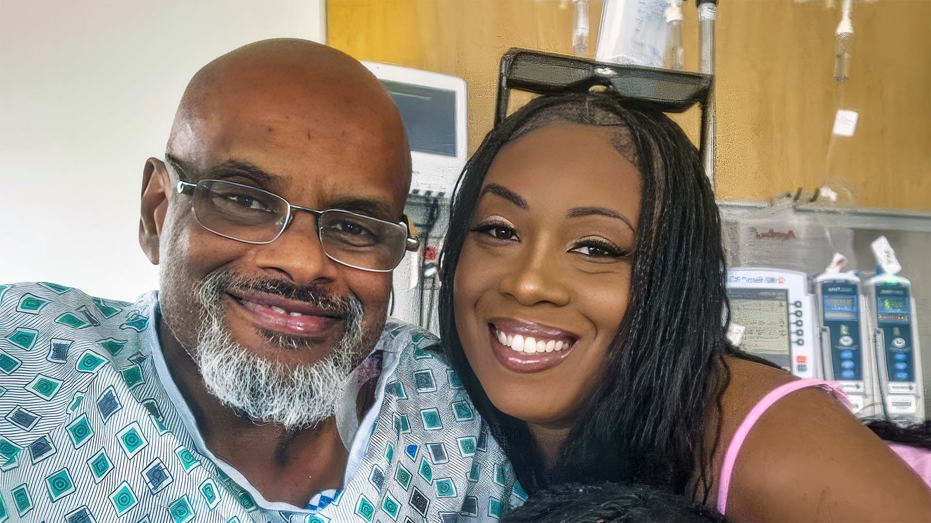 Marlin and his daughter smiling in his hospital room.