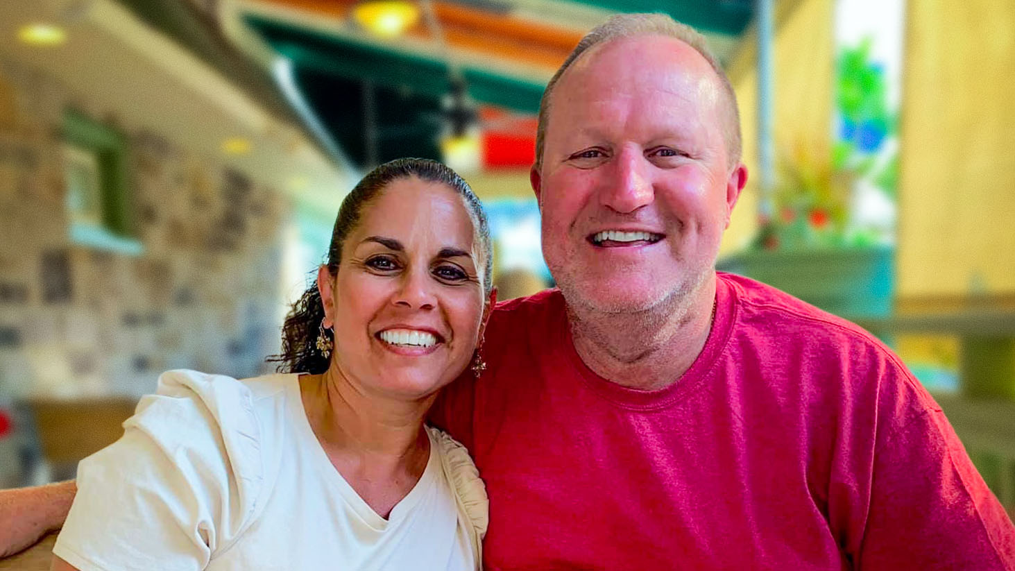 Scott and his wife seated together in an outdoor restaurant.