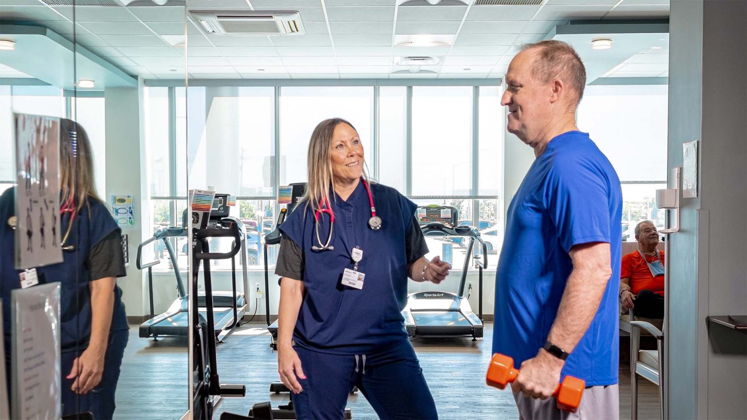 A healthcare professional engages with Scott during a rehab appointment.